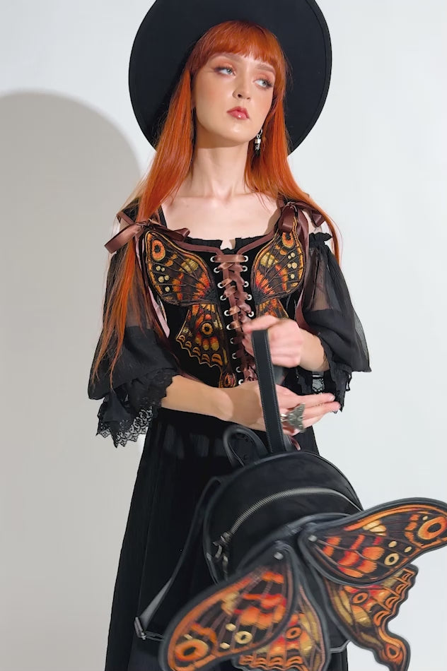 gothic woman wearing a novelty moth backpack