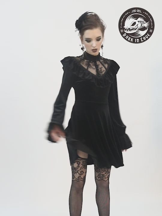 video showing model wearing short black gothic dress with ruffled collar and long sleeves
