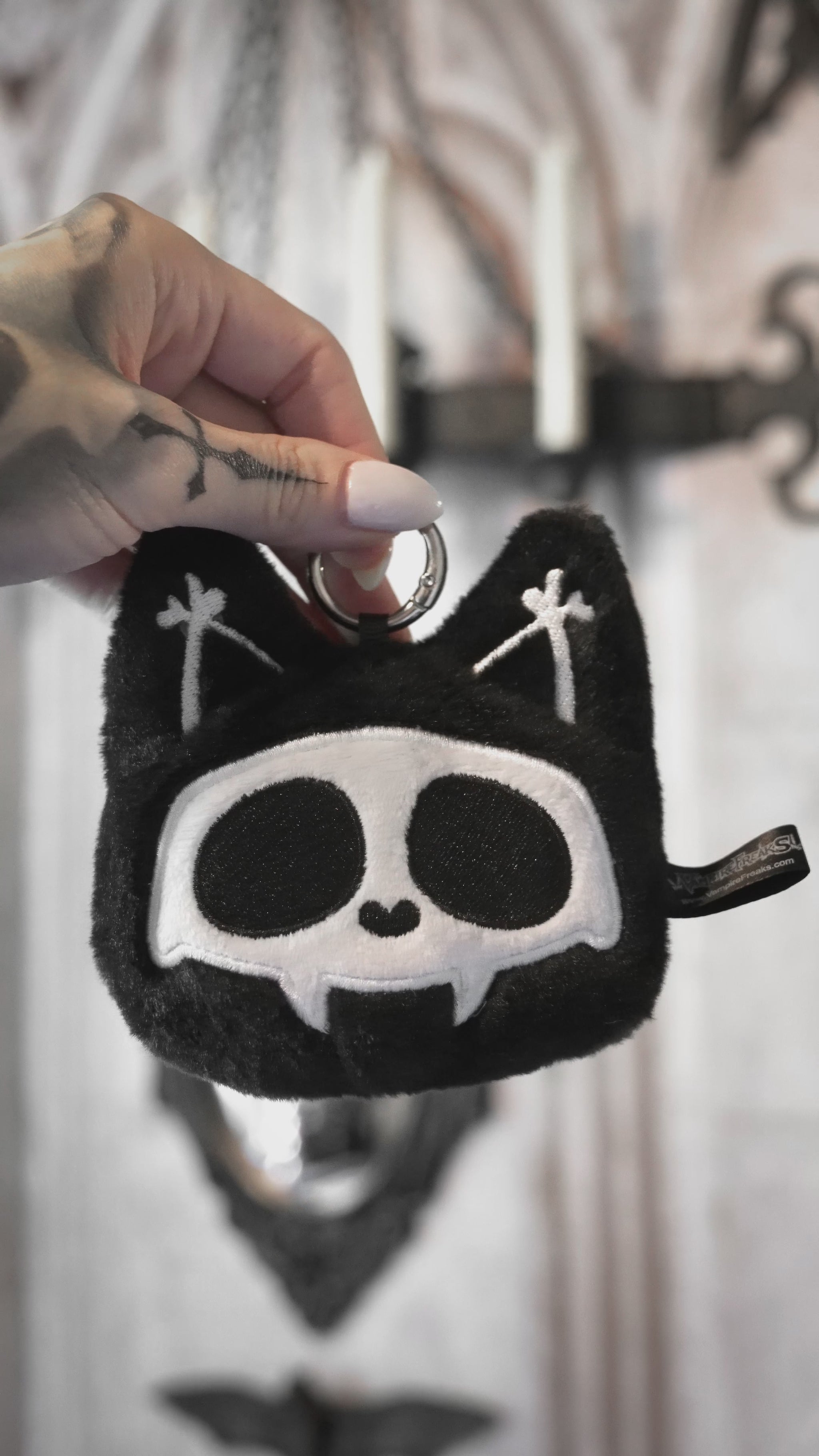 video of a small creepy cute skeleton cat bag charm for cash and coins