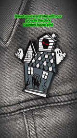 video of a glow-in-the-dark haunted house enamel pin