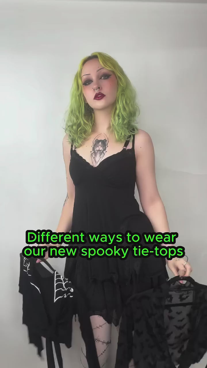 woman wearing a gothic black mesh long sleeve bat top