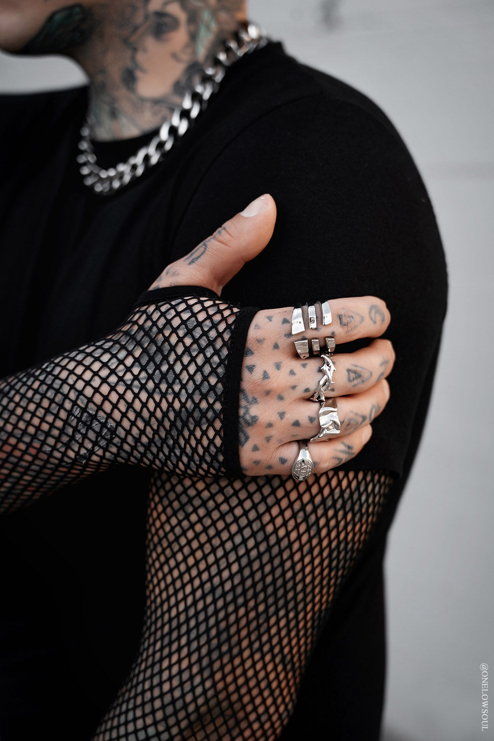 mens short sleeve black shirt layered over fishnet top