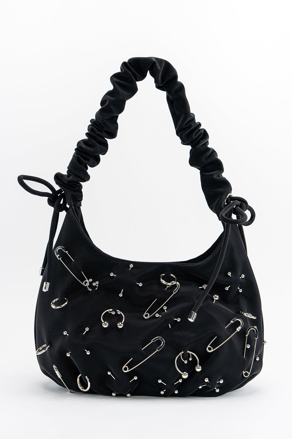 Black handbag with safety pin embellishments on a white background
