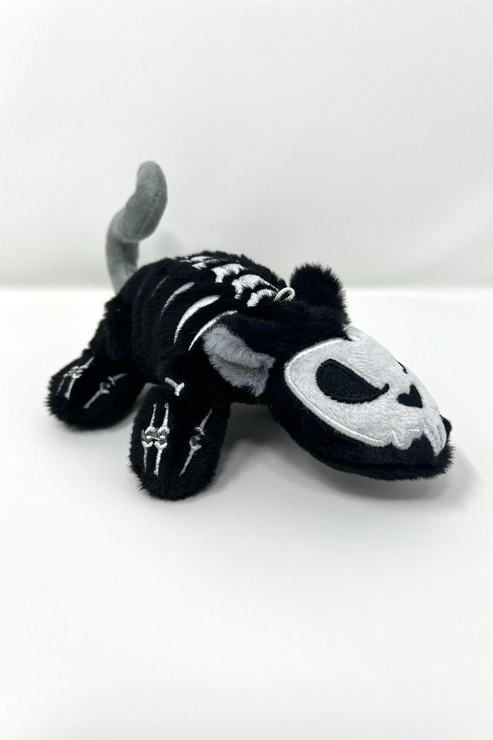 Black and white skeleton rat plush toy on a white background