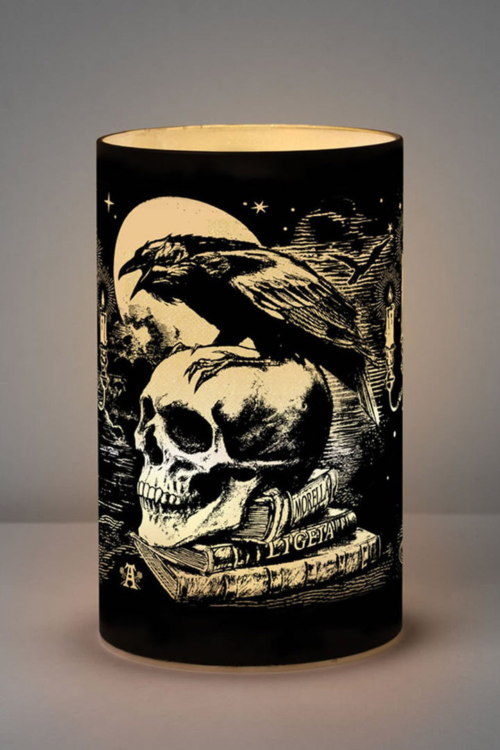 Decorative lamp with skull and raven design on a dark background