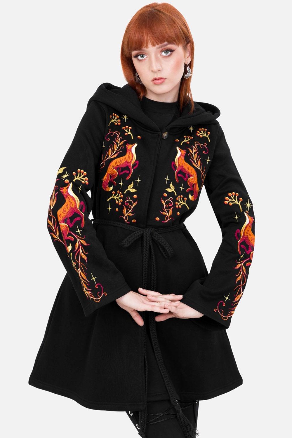 Black coat with colorful floral embroidery on sleeves worn by a model against a white background
