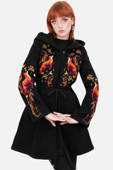 Black coat with colorful floral embroidery on sleeves worn by a model against a white background