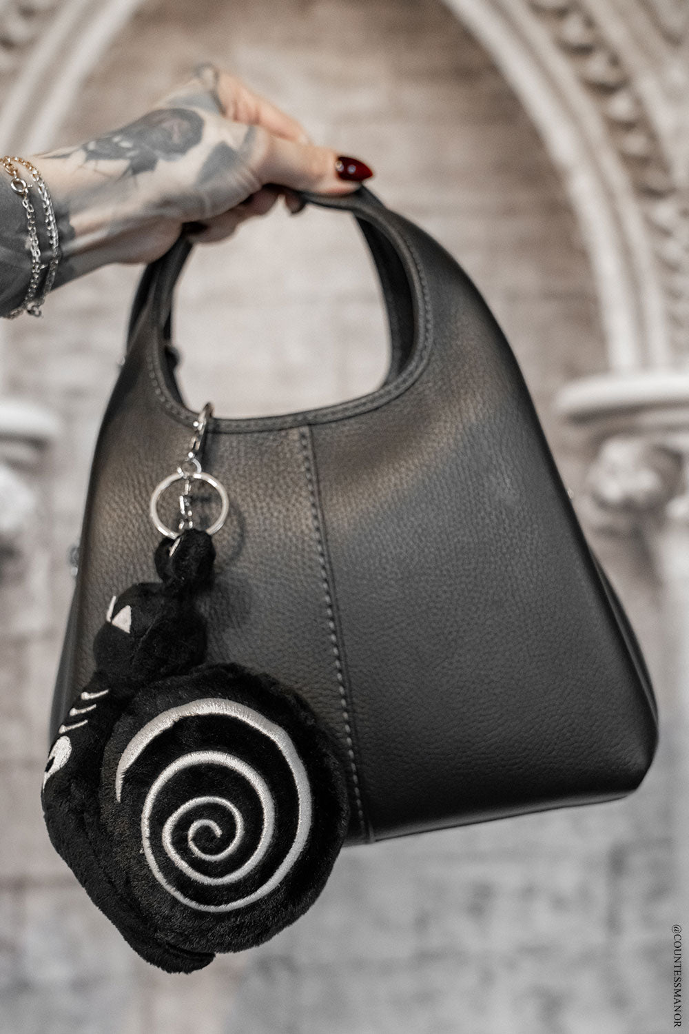 embroidered snail keychain on a gothic purse