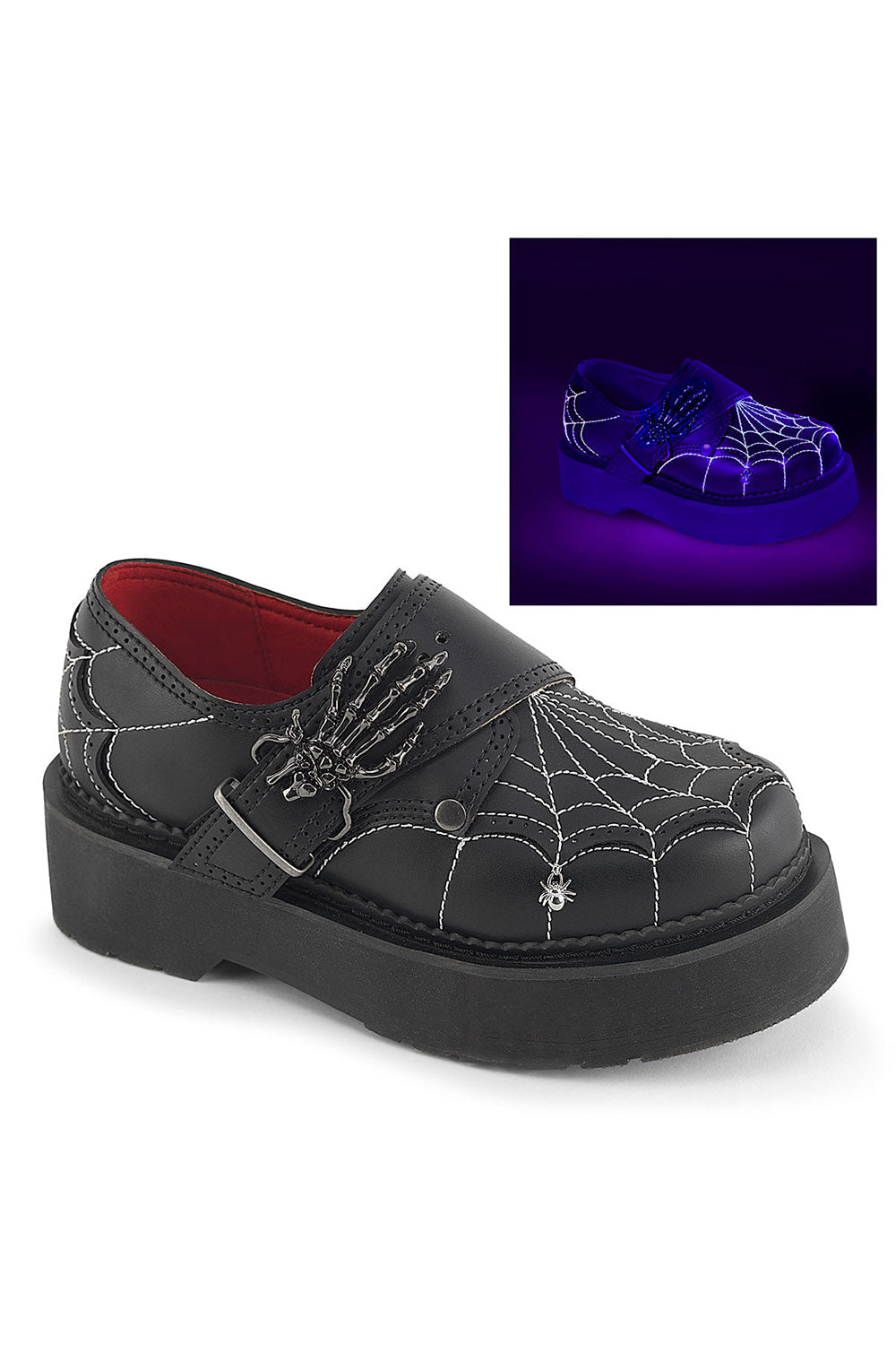 Black platform slip-on shoe with spiderweb embroidery, skeleton hand detail, and a small silver spider charm, shown on a white background with an inset demonstrating glow-in-the-dark effect under purple light.