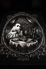 Gothic-style blanket with a ghost, cat, and skull teapot on a table within an ornate frame.