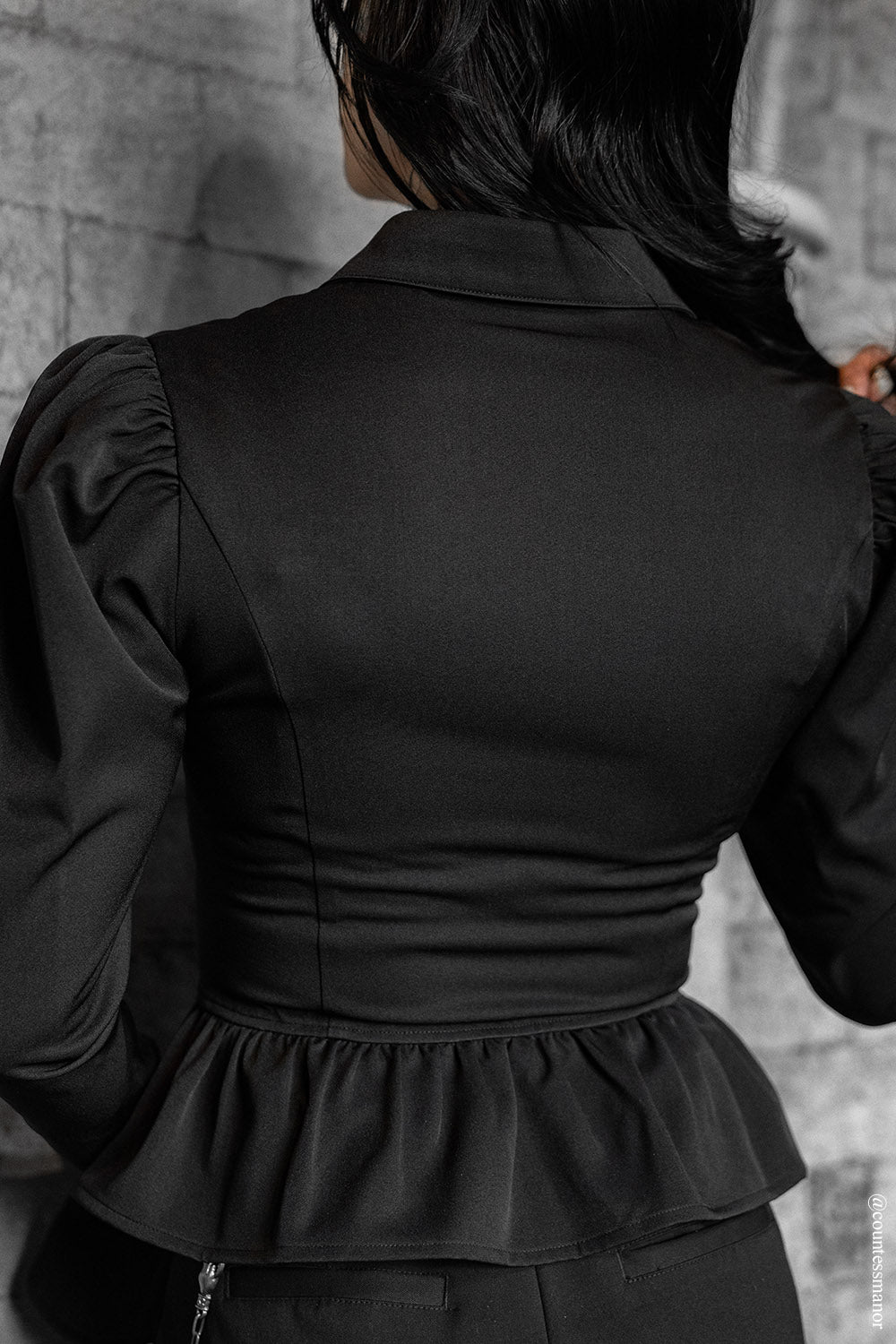 gothic woman wearing a black collared vampire goth long sleeve victorian top with flared sleeve cuffs