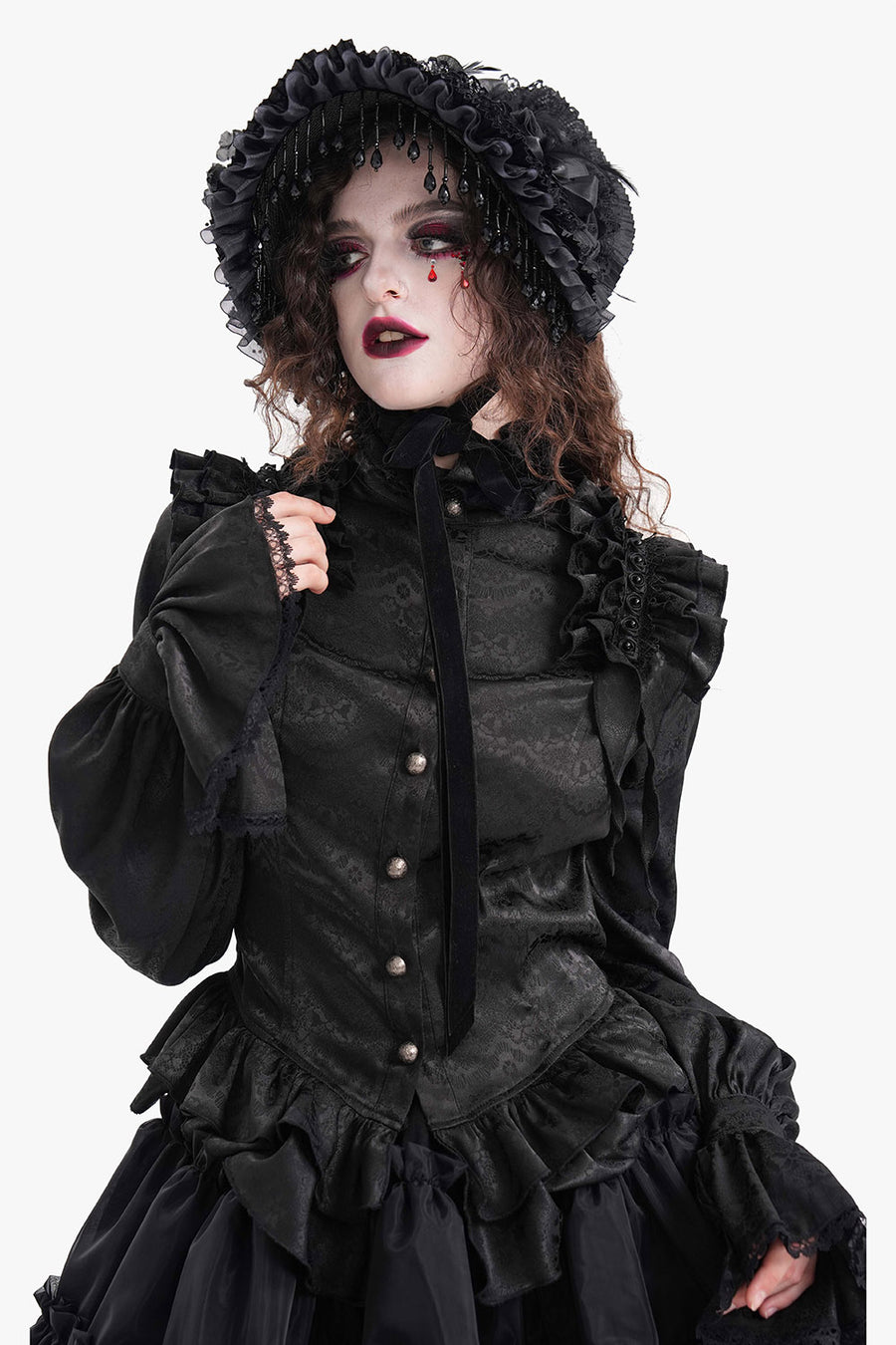 Person wearing a black gothic-style outfit with ruffles and a hood on a white background