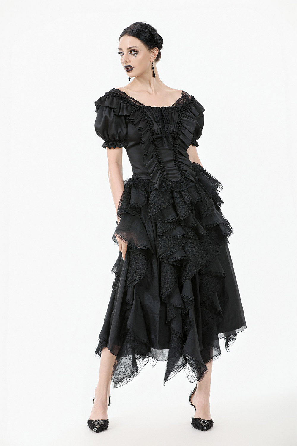 Black ruffled dress worn by a model on a white background