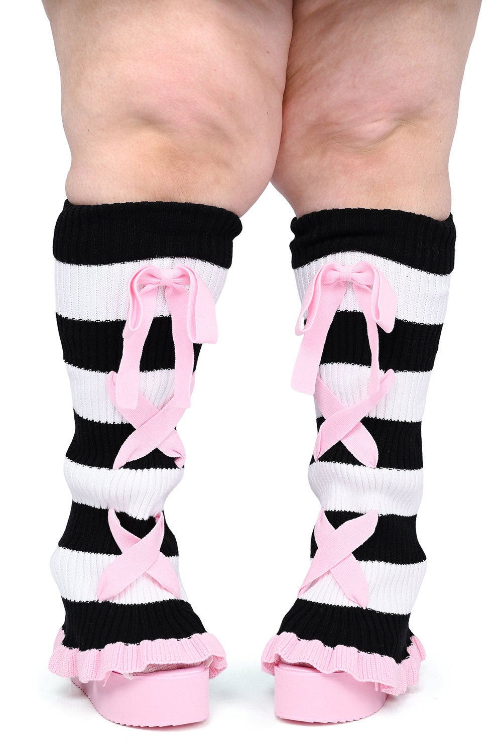 Black and white striped socks with pink bows worn by a plus size goth girl person on a white background