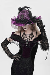 Person wearing a black and purple gothic outfit with a hat and gloves on a white background