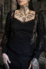 Person wearing a black lace top with tattoos on neck and arms in a dark setting