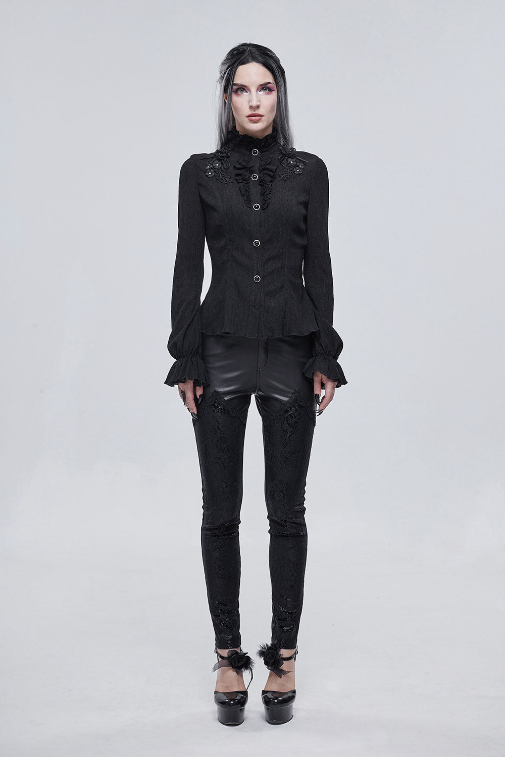 Person wearing a black gothic outfit on a white background