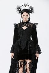 Woman wearing a black gothic outfit with a headpiece on a white background