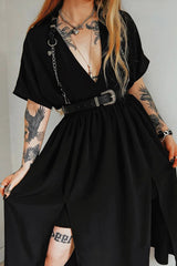 A person wearing a black gothic harness belt with silver chains and western buckles, featuring adjustable shoulder straps and a waist belt.