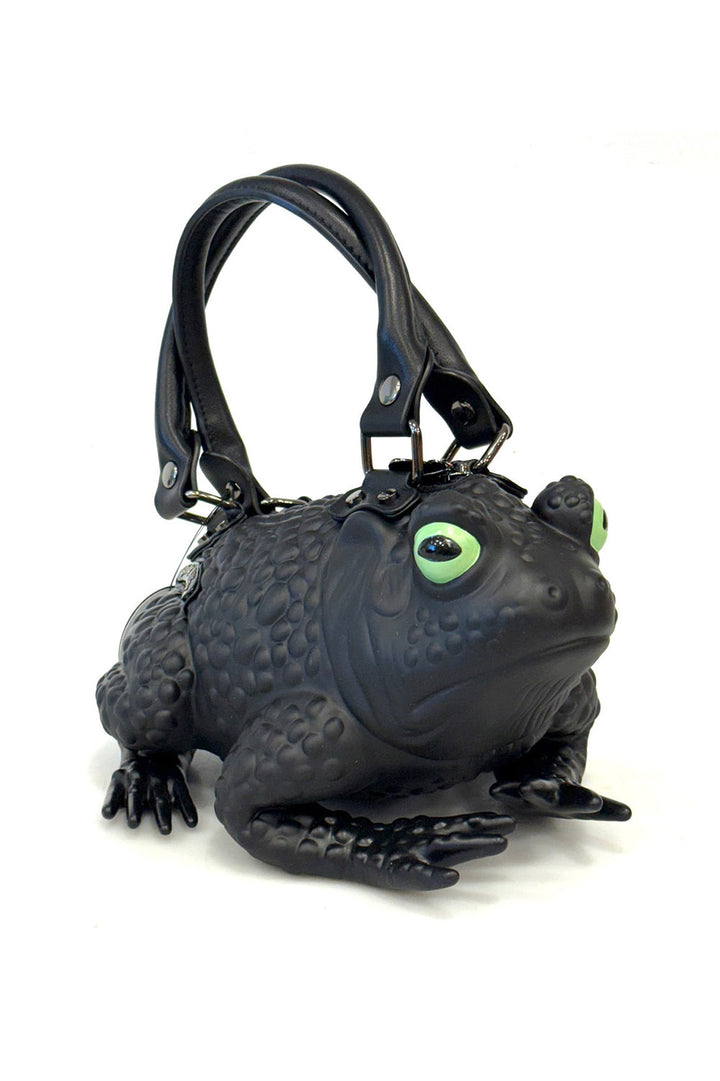 Black frog-shaped handbag with green eyes on a white background