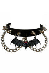 A black leather choker necklace with metal rivet spikes, chains, and a bat charm with red rhinestones.