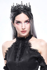 Woman wearing a black dress with lace details and a decorative headpiece on a white background